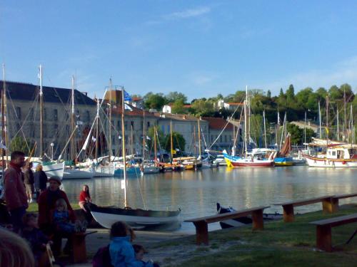 um grupo de pessoas sentadas ao lado de uma marina com barcos em Le Chai O Soleils em Mortagne-sur-Gironde