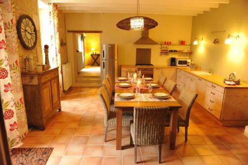 eine Küche mit einem Holztisch mit Stühlen und einem Esszimmer in der Unterkunft Le Chai O Soleils in Mortagne-sur-Gironde