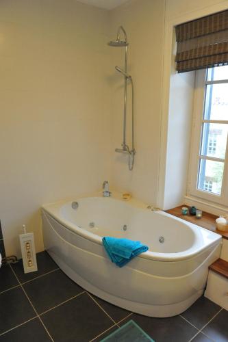 La salle de bains est pourvue d'une grande baignoire blanche. dans l'établissement Le Chai O Soleils, à Mortagne-sur-Gironde