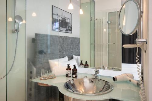 a bathroom with a sink and a mirror at INNSiDE by Meliá Bremen in Bremen