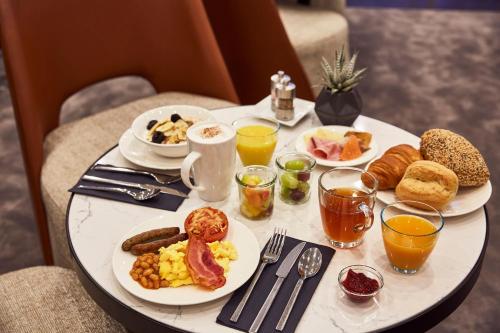 a white table with breakfast foods and drinks on it at INNSiDE by Meliá Bremen in Bremen