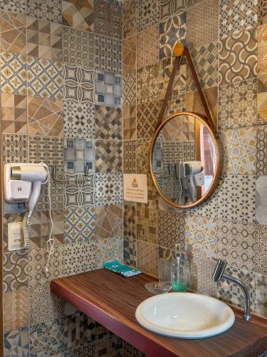a bathroom with a sink and a mirror at Pousada Vila dos Santos in Porto De Galinhas