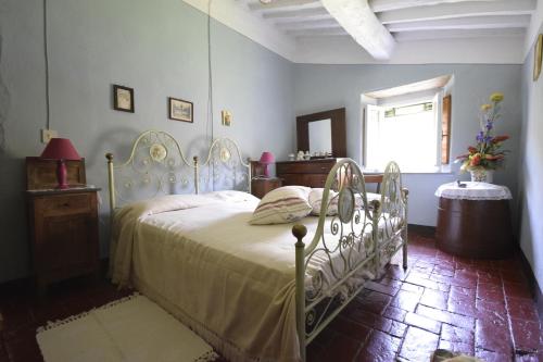 a bedroom with a white bed and a window at Casale Irene in Pescaglia