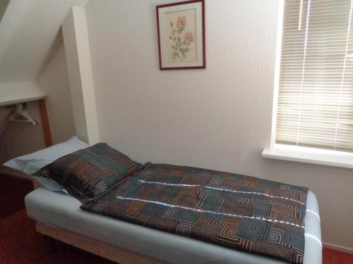 a small bed in a room with a window at B&B Korendijk in Zuid-Beijerland