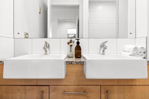 two sinks in a bathroom with two mirrors at Spacious Alpine View Resort in Wanaka