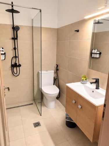 a bathroom with a toilet and a shower and a sink at Home Volos in Volos