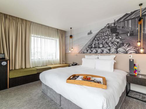 a hotel room with a large bed with a mural on the wall at Pullman Liverpool in Liverpool