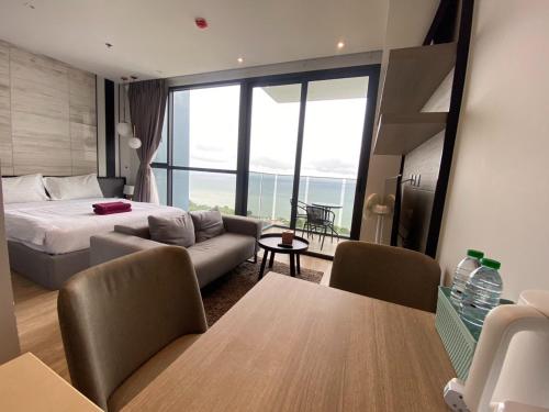 a bedroom with a bed and a couch and a table at Stunning Sea View Condo -Next To Beach in Pattaya South