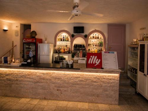 a bar with a lot of bottles of alcohol at Porto Sikinos Hotel in Alopronia