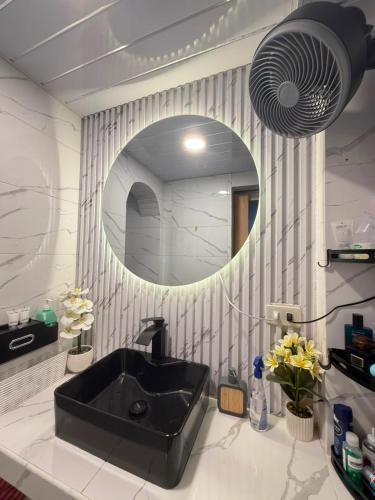 a bathroom with a black sink and a mirror at Casa De Jumeirah in Bacolod