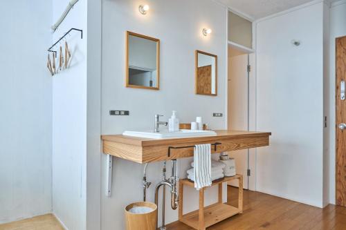a bathroom with a wooden sink and mirrors at WhyKumano in Nachikatsuura