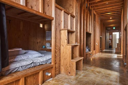 a hallway of a wooden building with beds in it at WhyKumano in Nachikatsuura