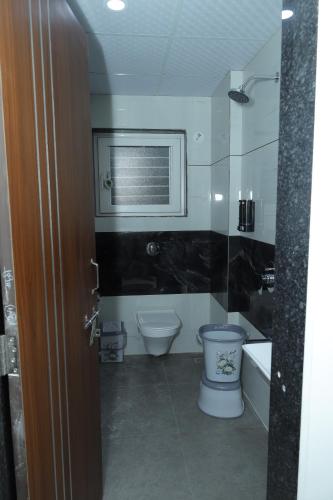 a bathroom with a toilet and a sink and a tub at Hotel Shreyash in Solapur