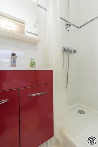 a red cabinet in a bathroom with a shower at Maison venitia t2 in Aussonne