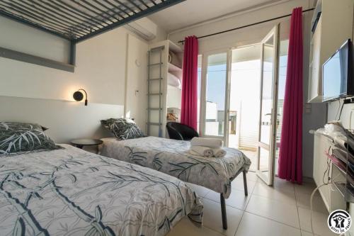 a bedroom with two beds and a laptop on a chair at Maison venitia t1 in Aussonne