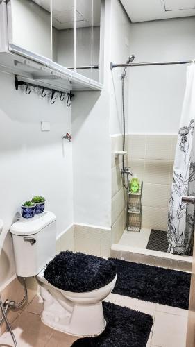 a white bathroom with a toilet and a shower at The Nook at Park in Ibaba