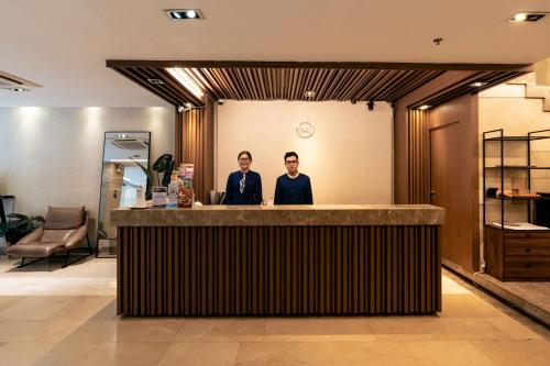 two men standing at a bar in a lobby at Nicecy Ben Thanh Hotel in Ho Chi Minh City