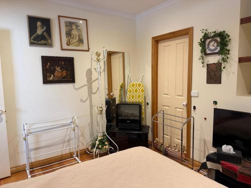 a bedroom with a bed and a television in it at Bethel Homestay in Watsonia North
