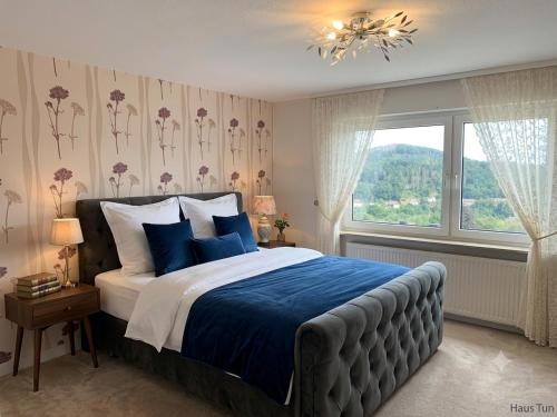 a bedroom with a bed with blue sheets and a window at Haus Tun in Gummersbach
