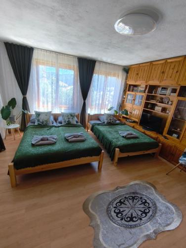 a bedroom with two beds with green sheets at Родопско сърце in Chepelare