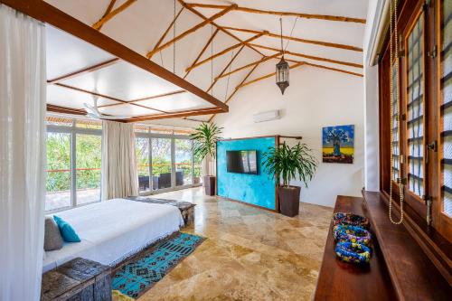 a bedroom with a bed and a large window at Tequila Sunrise Beach Villa-Diani Beach in Diani Beach