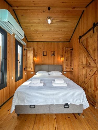 a bedroom with a large bed in a wooden room at Egem Tatil Evleri in Fethiye