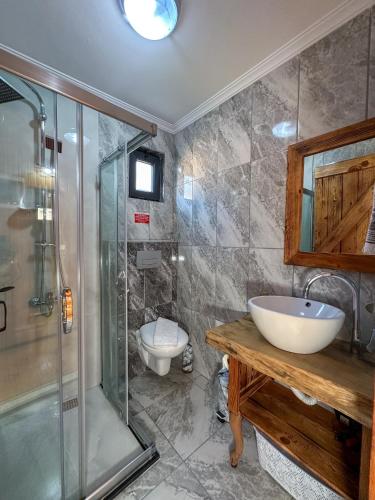 a bathroom with a shower and a sink and a toilet at Egem Tatil Evleri in Fethiye