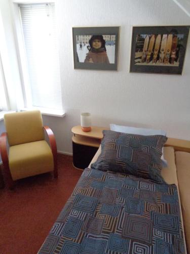 a bedroom with a bed and a chair and a window at B&B Korendijk in Zuid-Beijerland