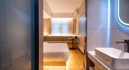 a small bathroom with a bed and a sink at H Life Hotel in Shenzhen