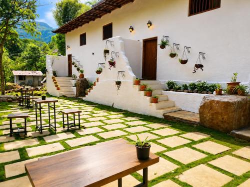 a patio with a table and chairs in front of a house at Achalaa Resort in Kolhapur