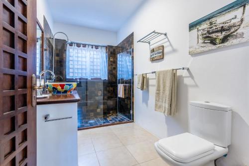 a bathroom with a toilet and a shower at Tequila Sunrise Pool Cabana-Diani Beach in Diani Beach