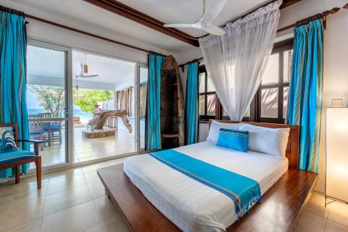 a bedroom with a bed and a large window at Tequila Sunrise Pool Cabana-Diani Beach in Diani Beach