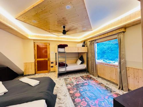 a bedroom with two beds and a window at Man Mauji Villa in Kasol