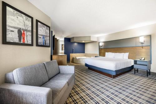 a hotel room with a bed and a couch at AmericInn by Wyndham Albert Lea in Albert Lea