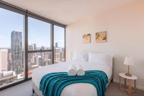 a bedroom with a bed with two white slippers on it at Park Avenue - UNO Melbourne in Melbourne