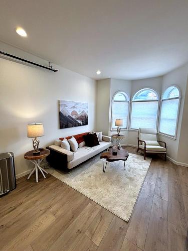 a living room with a couch and two windows at The Rustic Revival - Charming 2BR Retreat in St. Charles