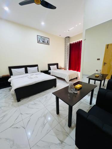 a bedroom with two beds and a living room at Black Forest Hotel in Kalām