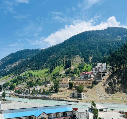 a town on a hill next to a river at Black Forest Hotel in Kalām