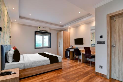 a bedroom with a bed and a desk with a computer at Palette Dumdum Airport Formerly Seventy-Seven in Dum Dum