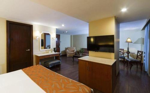 a hotel room with a bed and a living room at Hotel Veniz in Baguio