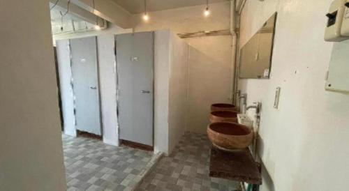 a row of toilets in a bathroom with four urinals at Chinawat Hotel in Sukhothai