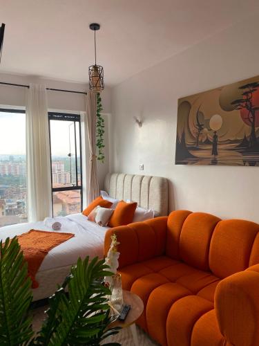 a living room with a bed and a couch at Suite Life in Kiambu
