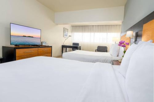 a hotel room with two beds and a flat screen tv at Radisson Hotel Santo Domingo in Santo Domingo