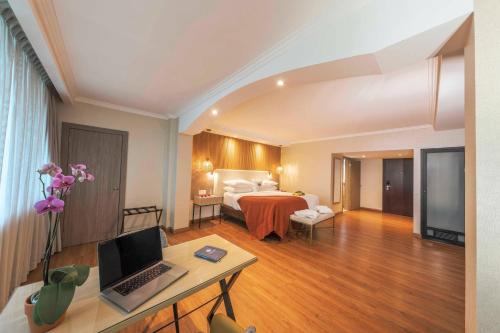 a hotel room with a bed and a desk with a laptop at Hotel El Panama by Faranda Grand, a member of Radisson Individuals in Panama City