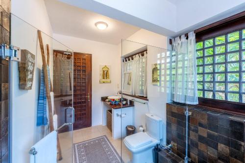 a bathroom with a toilet and a glass shower at Tequila Sunrise Sky Cabana-Diani Beach in Diani Beach