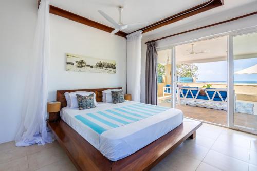 a bedroom with a bed with a view of the ocean at Tequila Sunrise Sky Cabana-Diani Beach in Diani Beach
