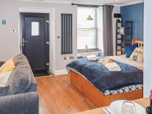 a bedroom with a large bed and a couch at The Old Post Office in Kingskettle