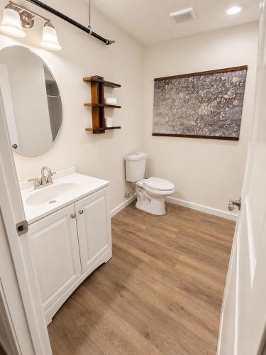 a bathroom with a white sink and a toilet at The Bourbon & Brass - Speakeasy-Inspired 2BDR in St. Charles