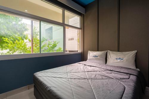 a bedroom with a bed with two pillows and a window at Krungthai Hotel at Rangnam in Sathani Sam Sen