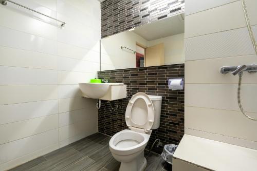 a bathroom with a toilet and a sink at Krungthai Hotel at Rangnam in Sathani Sam Sen